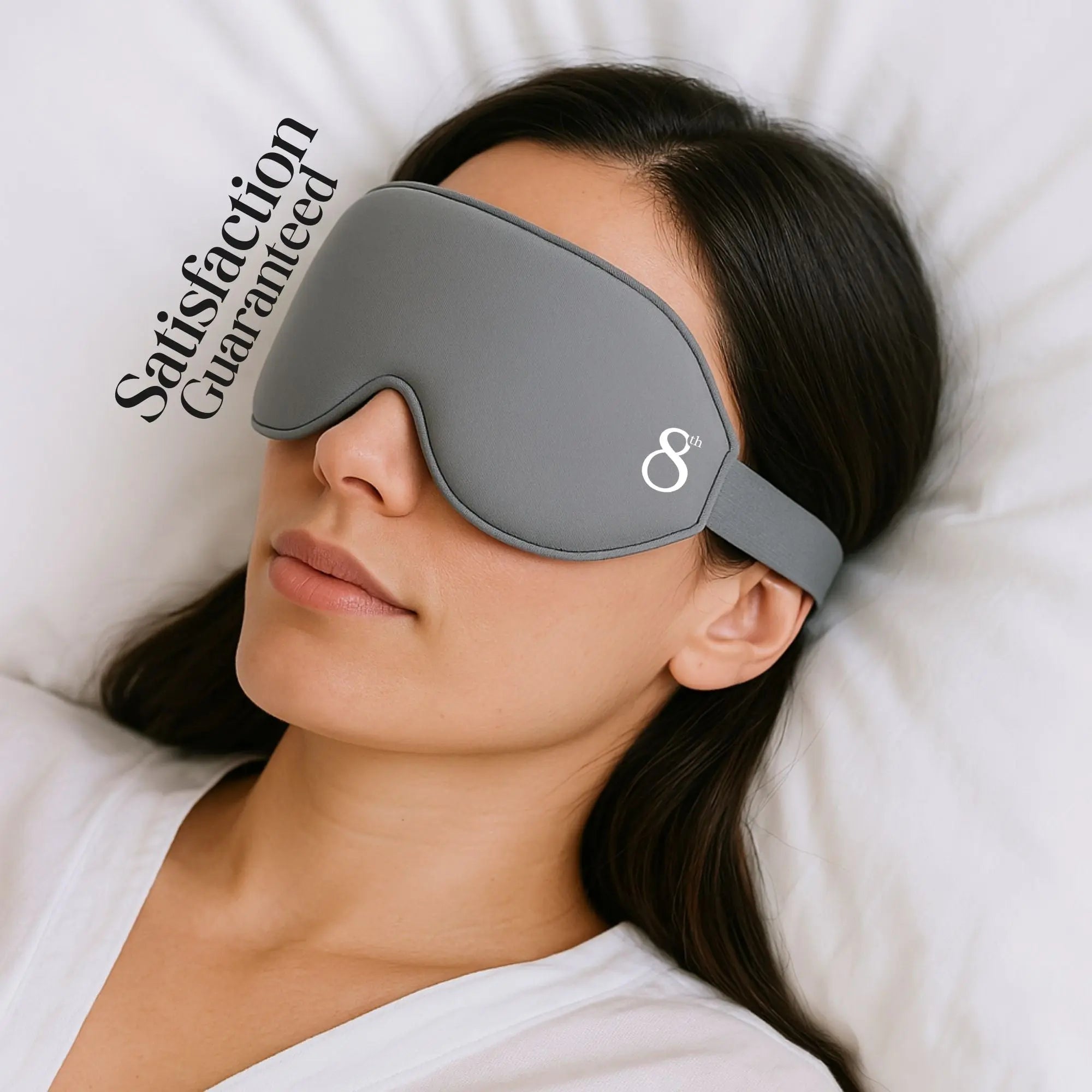 The 8th branded high quality sleeping mask in gray worn by a woman lying on a white pillow